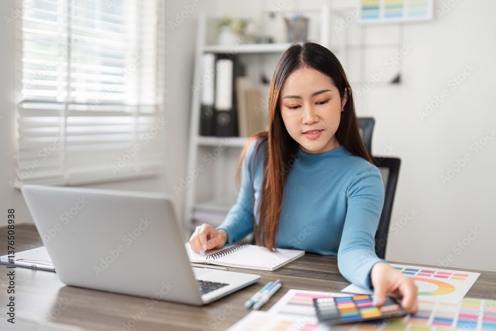 Creative Process and Color Selection. A designer contemplating color choices while working on her laptop. Creative Process and Color Selection. A designer contemplating color choices while working on her laptop.
