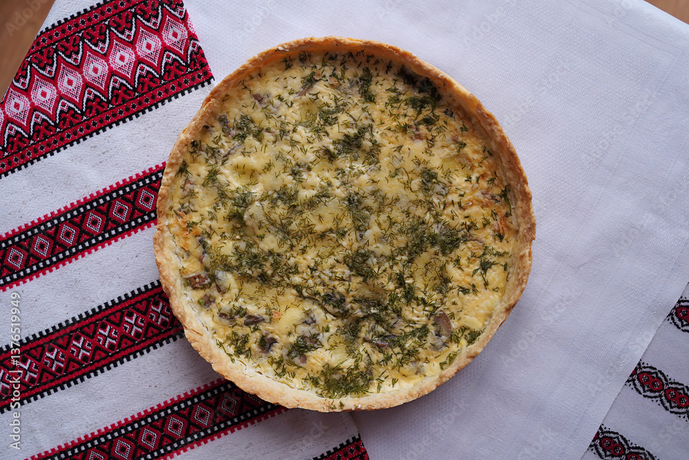 Homemade quiche pie or tart. Food on the traditional Ukrainian table with embroidered tablecloth.