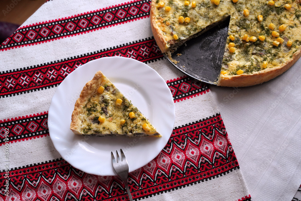Homemade quiche pie or tart. Food on the traditional Ukrainian table with embroidered tablecloth.