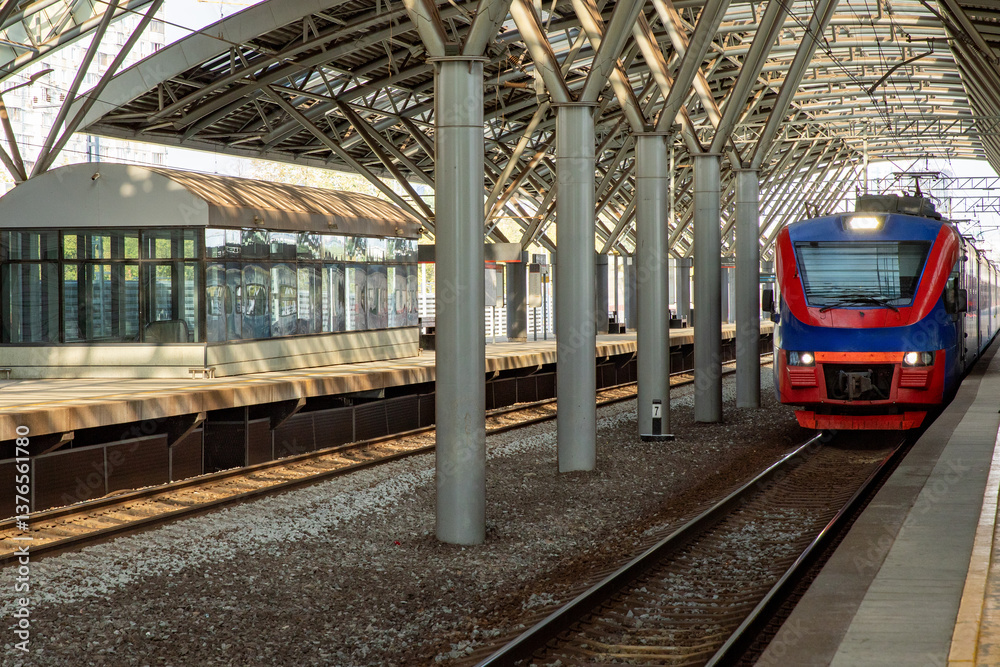 Naklejka premium Local train arrive to railway station platform in Russia. Train station. Modern railway transportation concept. Railroad. Commercial transport