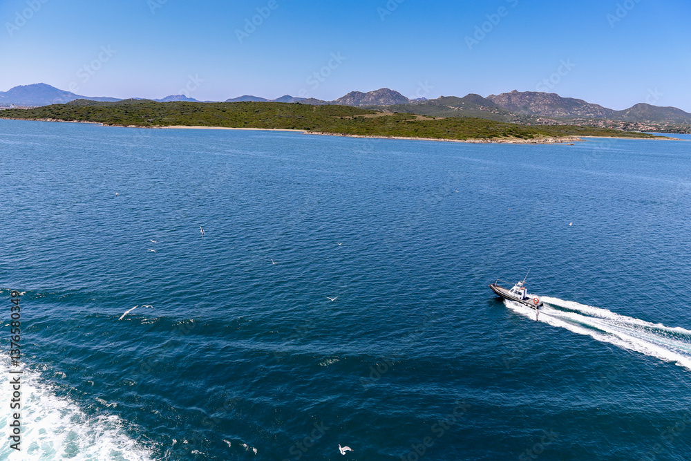 Obraz premium A boat is traveling across a large body of water near island Sardinia Italy