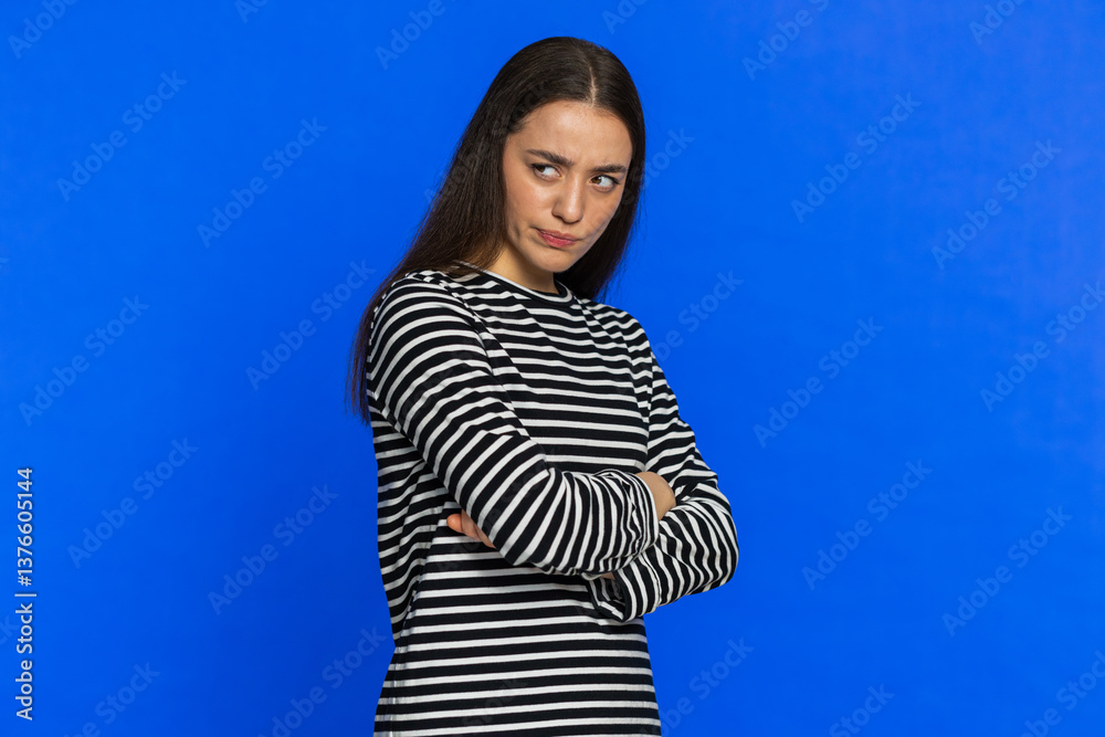 Fototapeta premium Offended sad nervous Caucasian woman having misunderstanding, frustrated after quarrel, fail, lose, ignores and does not want to communicate, talk. Girl isolated on blue background. Tired people