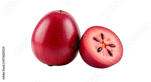 Close up of a whole and halved camu camu fruit revealing seeds on a black isolated background