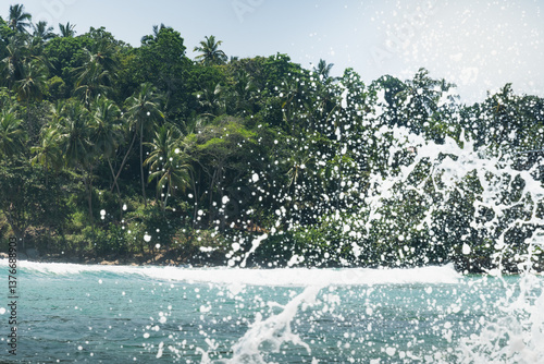 Obraz na płótnie Tropical beach with palms tree and clear blue ocean splash for surf. Summer landscape, travel concept. Inside wave. w salonie