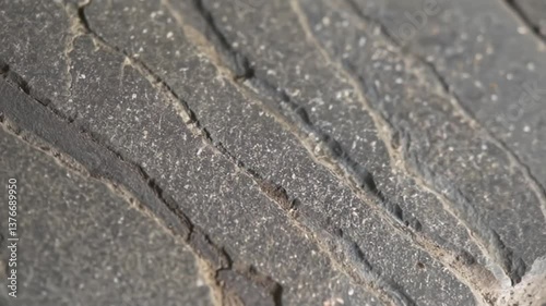 Worn tire tread, close-up, black and grey, representing wear and tear