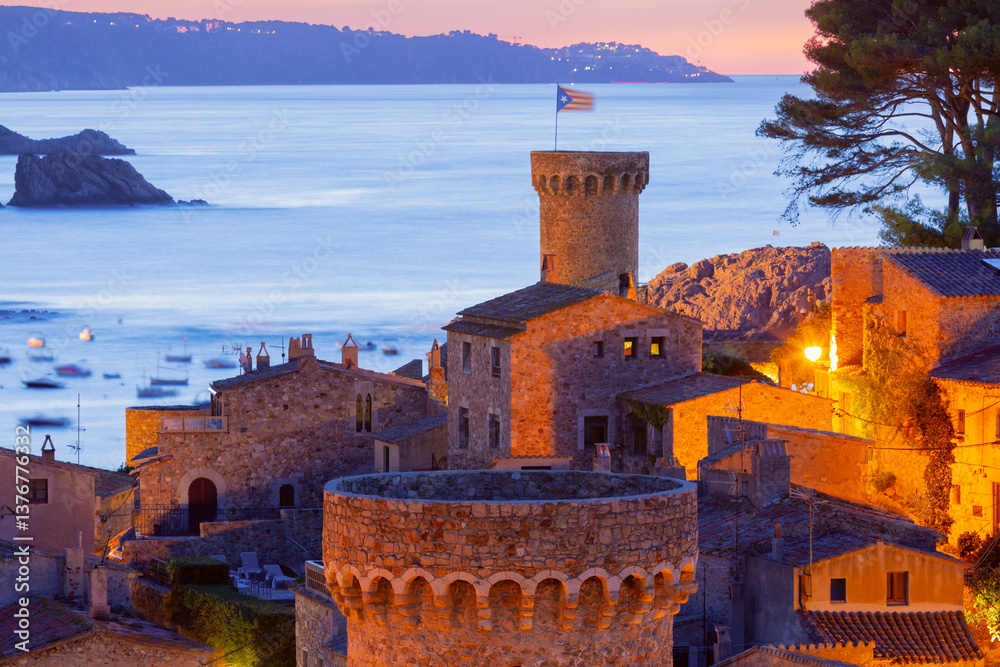 Medieval stone towers and coastal village at sunrise in Tossa de Mar, Spain