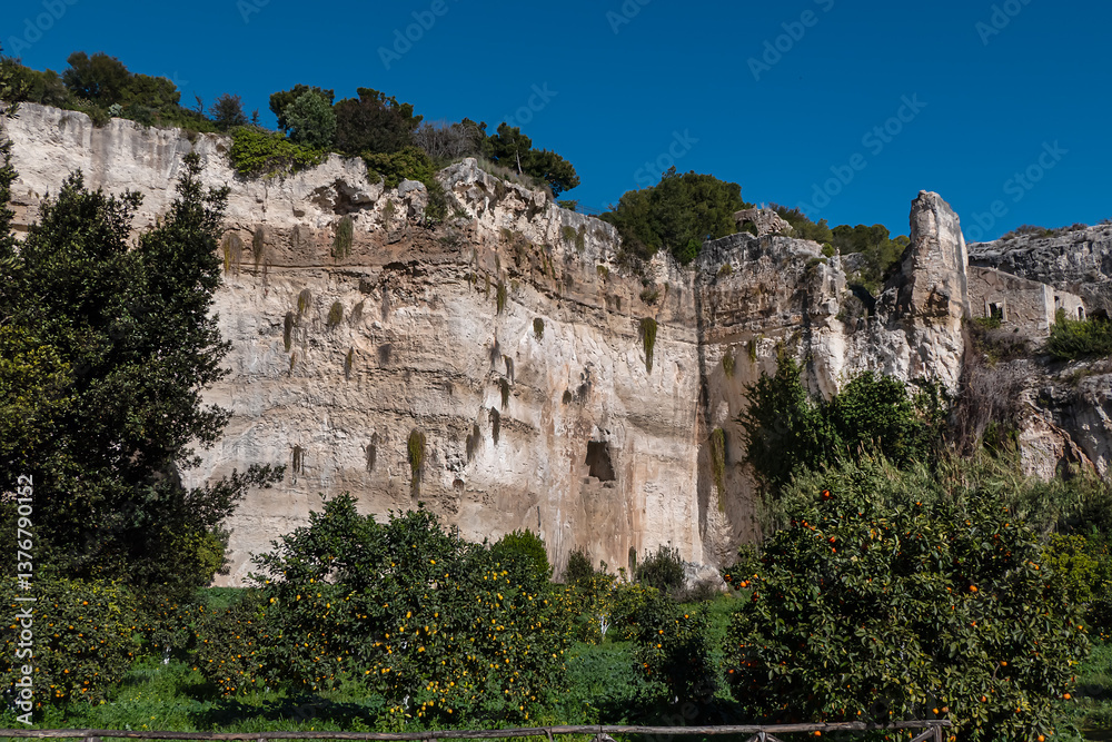 Beautiful garden with Mediterranean vegetation and numerous caves - Paradise stone quarry (Latomia del Paradiso). Syracuse, Sicily, Italy.