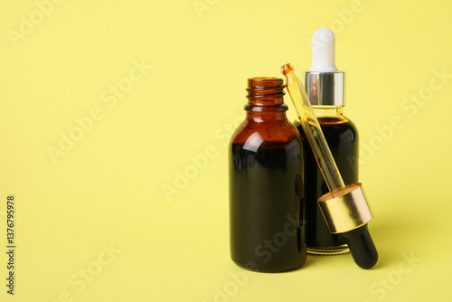Bottles with iodine and pipette on yellow background, closeup