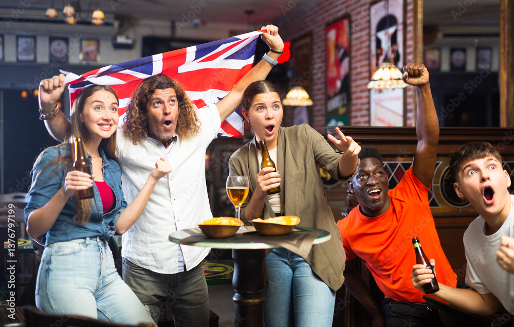 Obraz premium Group of emotional friends, football fans, having fun in sports bar, cheering for favorite British team together while watching match