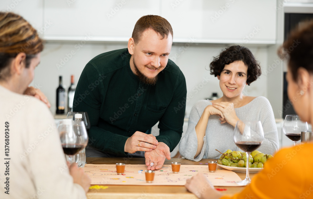 Two married couples are having fun in cozy home atmosphere, playing board game. Player makes lead move and believes in luck, emotionally waiting for victory Two married couples are having fun in cozy home atmosphere, playing board game. Player makes lead move and believes in luck, emotionally waiting for victory