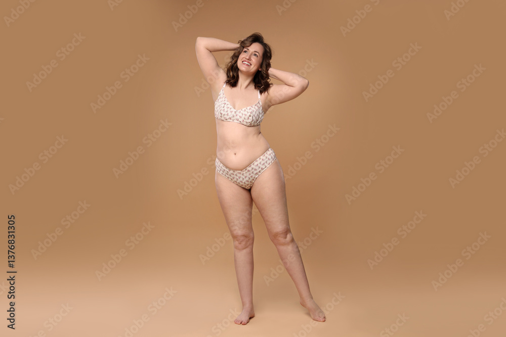 Fototapeta premium Beautiful woman in underwear on dark beige background. Cellulite problem