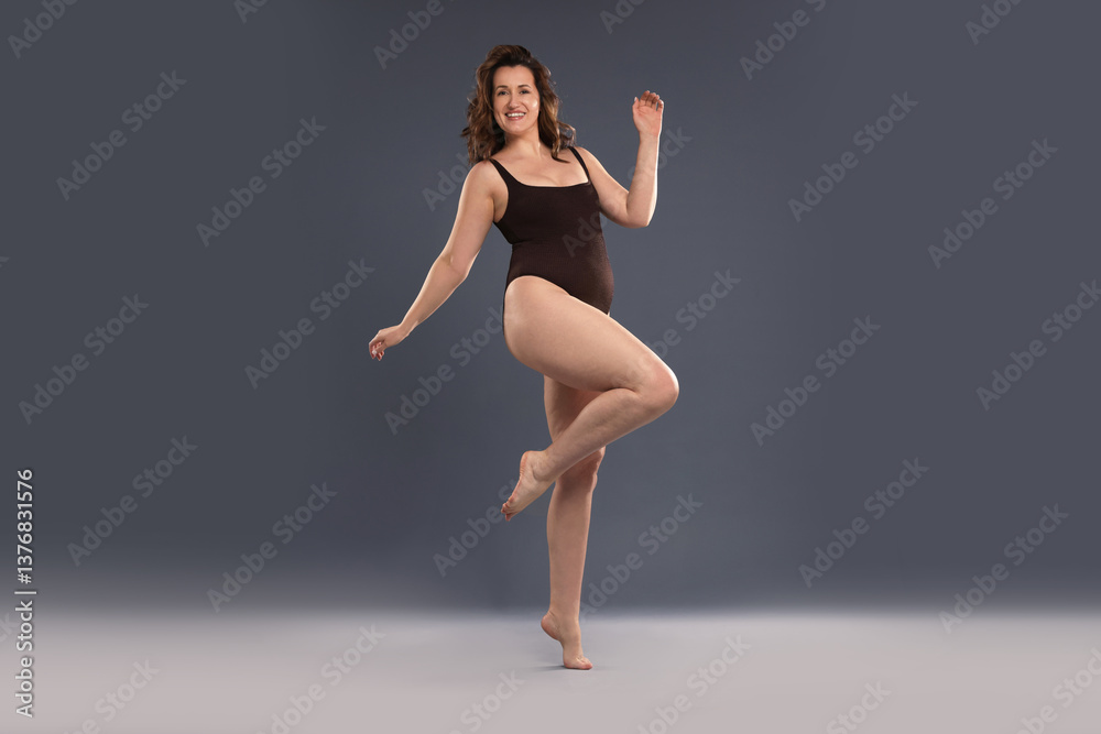 Obraz premium Beautiful woman in bodysuit on dark grey background. Cellulite problem