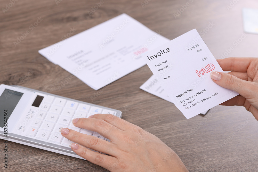 Obraz premium Paying bills. Woman with different invoices and calculator at wooden table indoors, closeup