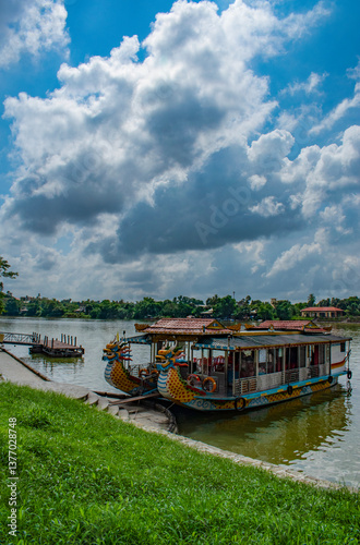Hue, Vietnam, 10-11-2025: boats in the shape of dragons on the Huong River (Perfume River), a river crossing the city of Hue. In the autumn, flowers from orchards upriver from fall into the water, giv