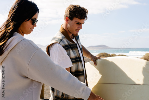 Surfing enthusiasts chat as they head to the shore to surf