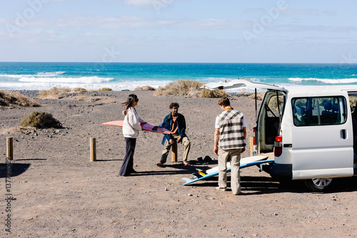 Young adventurers unloading their surfboards from a van