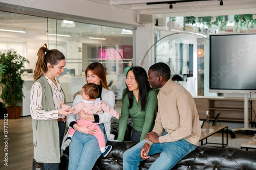 Diverse group in an office setting embracing new parenthood