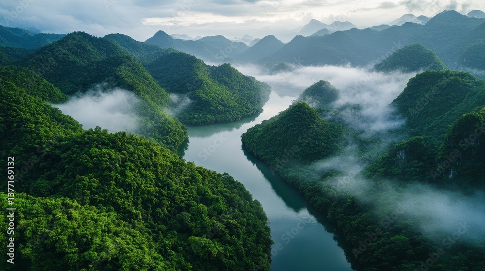 Obraz premium Lush green mountains and serene river with misty clouds in tranquil landscape