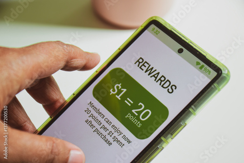 Example of customer loyalty programs in e-commerce. Reward points earned after purchase. Female hand holding a mobile phone, digital display, selective focus.