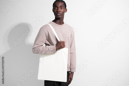 Man carrying blank canvas tote bag mockup 