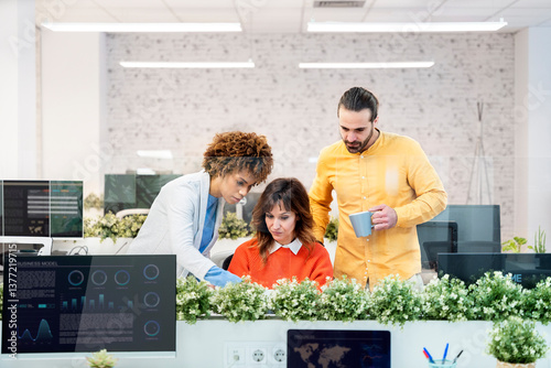 Office workers collaborating on project using laptop