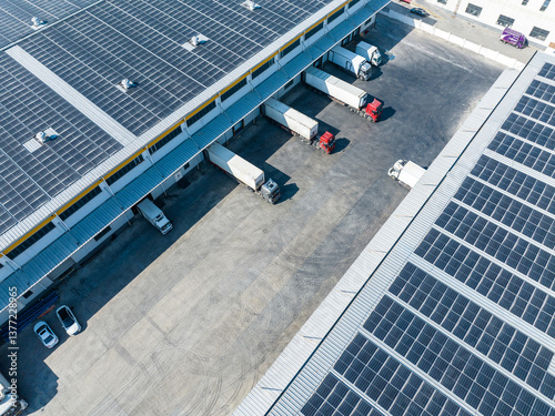 Aerial View of Factory with Solar Panels and Transport Trucks