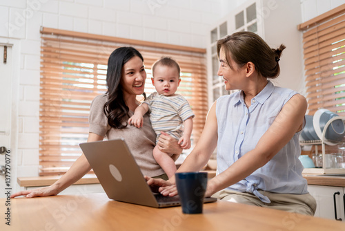 Asian lesbian couple lovingly care for and raises their baby boy at home.	
