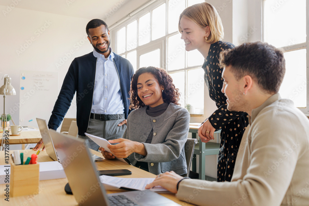 © BONNINSTUDIO/Stocksy - Happy formal business team celebrating success in office meeting