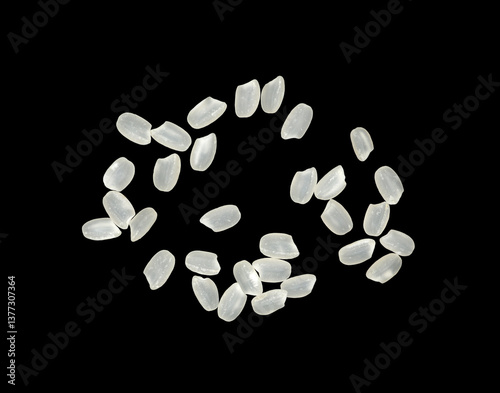 The top view is a rice splash fly isolated on a black background. raw grain texture, pile seed white. food healthy
