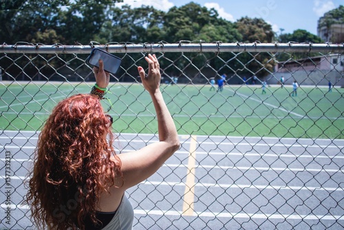 Soccer mom clapping her son playing a soccer match