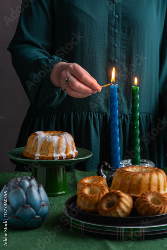 A woman in a green dress lights candles for the Easter holiday.