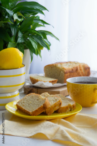 On the table in a yellow plate are cut pieces of lemon cake.
