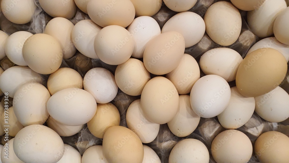 Close up of randomly stacked chicken eggs sold at the market as a background. Close up of randomly stacked chicken eggs sold at the market as a background.