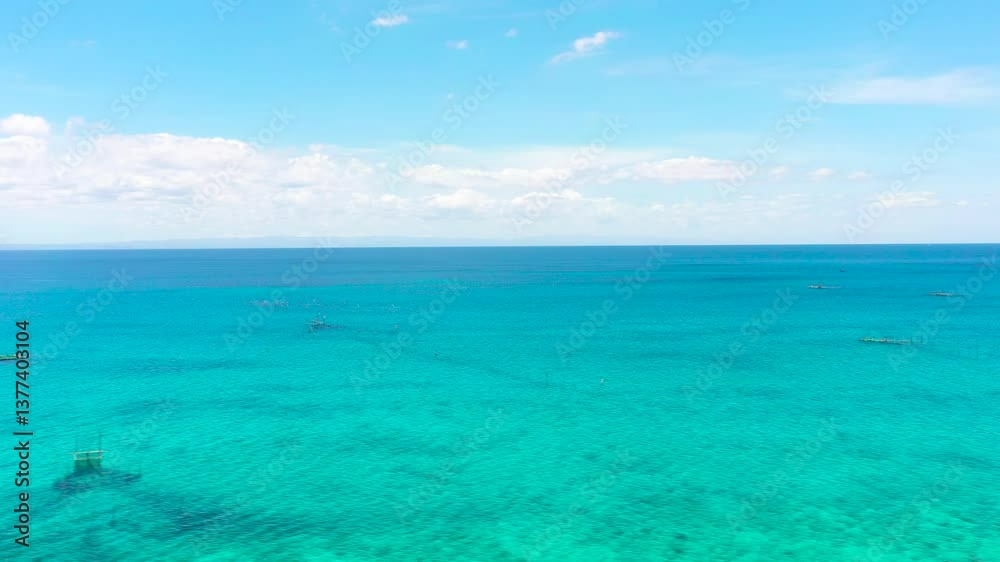 Sea surface with corals and turquoise clear waters. Blue sky and clouds. Seascape. Bantayan, Cebu, Philippines. Sea surface with corals and turquoise clear waters. Blue sky and clouds. Seascape. Bantayan, Cebu, Philippines.