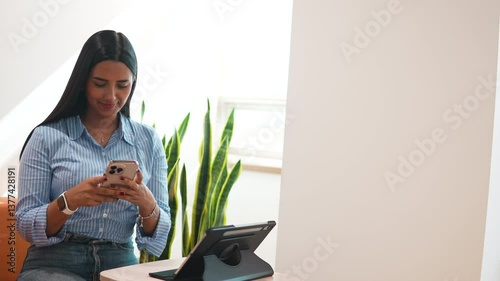 Happy female manager working with mobile technology in startup company