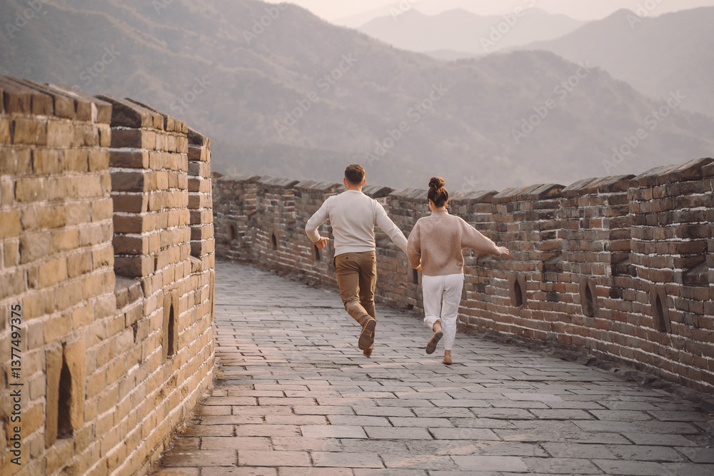 young couple running and twirling at the Great Wall of China