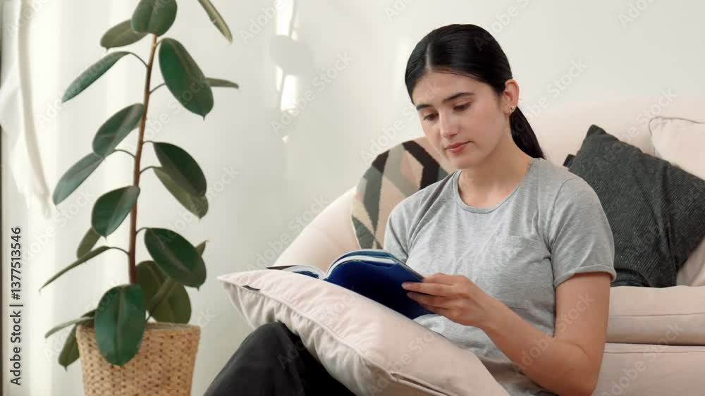 Woman sitting on sofa indoor reading textbook increase knowledge about social and technology for occupation or raise children to be good adult as smart mother. Lifelong learning concept. Divergence.
