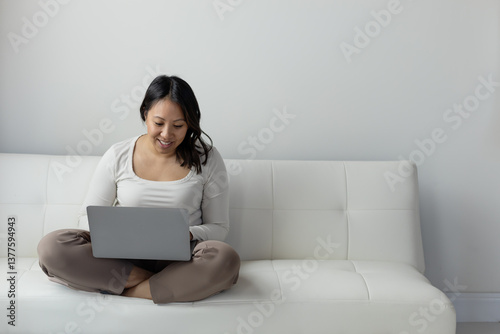 Diverse woman on zoom call sitting on couch photo
