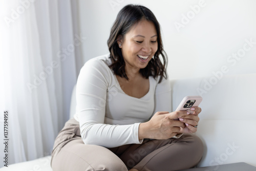 Woman laughing while reading a text message photo