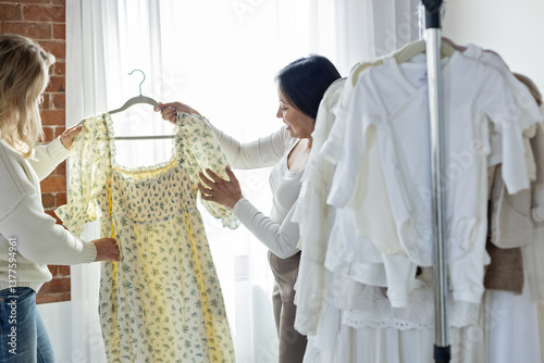 Consultant showing a shopper a dress photo