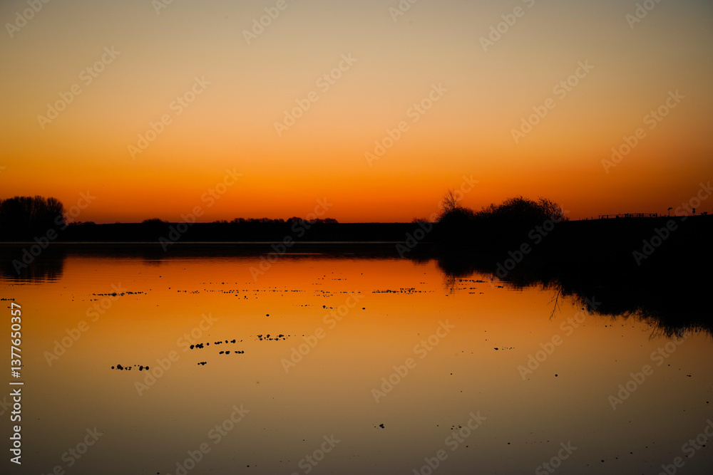 Obraz premium Wunderschöner Sonnenaufgang im Frühling. Auflaufend Wasser und der Blick über die Hunte in Richtung Osten. 