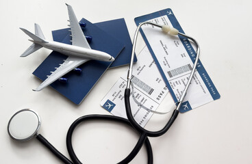 international medical travel insurance concept, stethoscope, passport and airplane isolated on white background