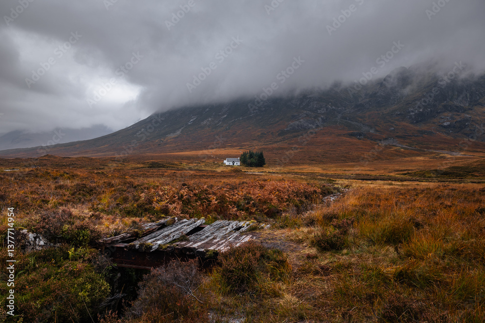 Dramatic peaks and misty valleys define Glen Coe, Scotland’s iconic Highland landscape. Golden light dances on rugged slopes, creating a scene of wild, untamed beauty.