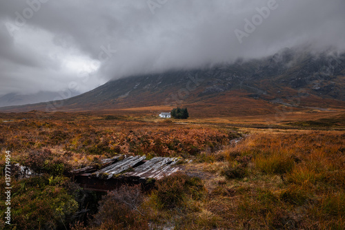 Obraz na płótnie Dramatic peaks and misty valleys define Glen Coe, Scotland’s iconic Highland landscape. Golden light dances on rugged slopes, creating a scene of wild, untamed beauty. w salonie
