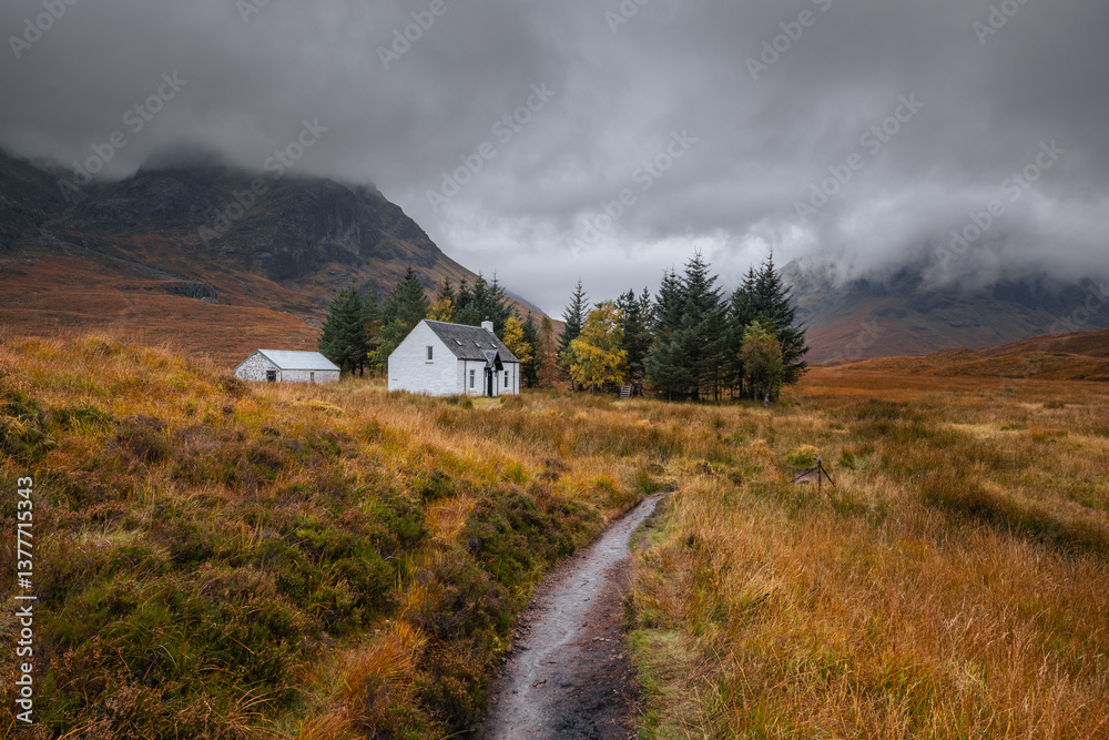 Dramatic peaks and misty valleys define Glen Coe, Scotland’s iconic Highland landscape. Golden light dances on rugged slopes, creating a scene of wild, untamed beauty.