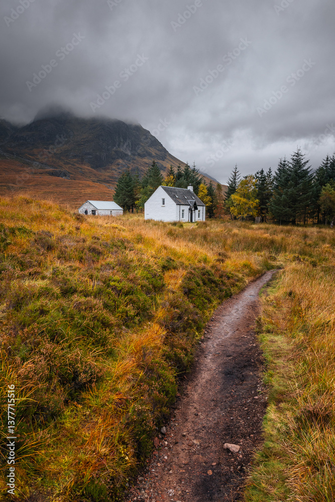 Dramatic peaks and misty valleys define Glen Coe, Scotland’s iconic Highland landscape. Golden light dances on rugged slopes, creating a scene of wild, untamed beauty.