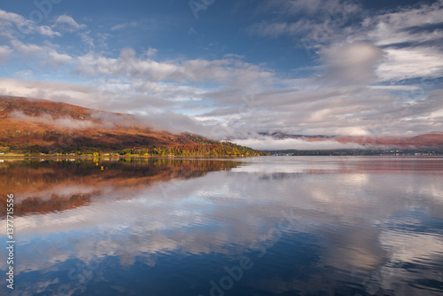 Obraz na płótnie Golden light bathes Corpach’s shores, where the iconic shipwreck rests against Ben Nevis’ misty peaks. A serene autumn morning unfolds over Scotland’s rugged beauty. w salonie