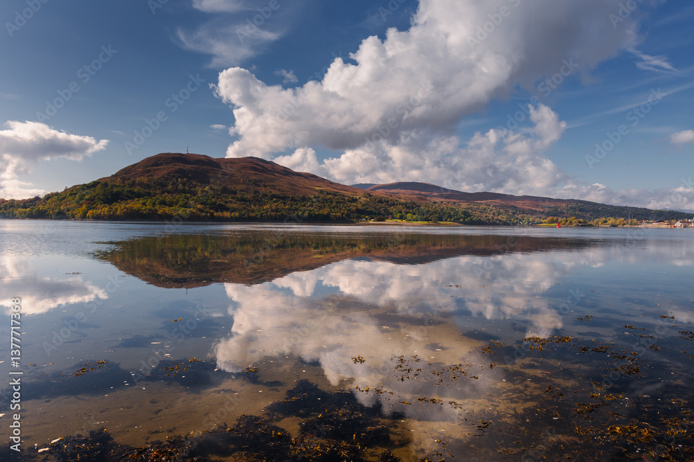 Golden light bathes Corpach’s shores, where the iconic shipwreck rests against Ben Nevis’ misty peaks. A serene autumn morning unfolds over Scotland’s rugged beauty.