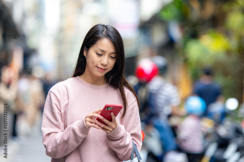 Young woman walking with cellphone in city town
