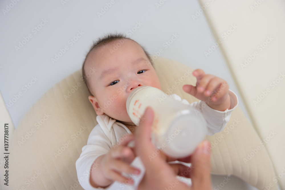 Cute baby drinking milk from feeding bottle